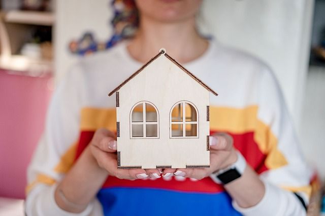 chica con casa de madera en sus manos